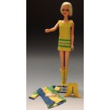 A Mattel Twiggy Barbie doll, wearing a yellow woollen mini dress and long yellow boots, 26.