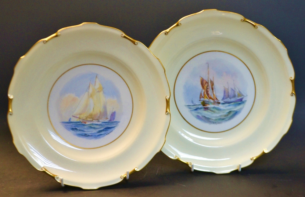 A pair of Royal Crown Derby shaped circular plates, painted  by W.E.