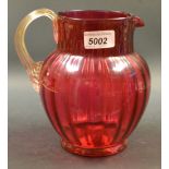 A Victorian cranberry glass ovoid water jug, clear glass reeded scroll handle, 19cm,