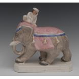 A Victorian Staffordshire model of an elephant, with a sultan seated, pink and blue trim cloth,