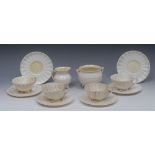 Three Belleek Nautilus pattern teacups and saucers, washed in yellow,