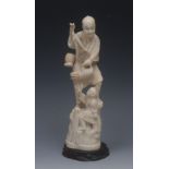 A Japanese ivory okimono, of a fisherman and his boy, he stands holding fish, the child at his feet,