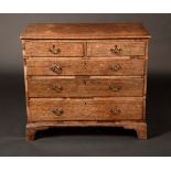 A George III oak chest of two short drawers over three long, pierced brass escutcheons,