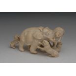 A Japanese ivory okimono, carved as an elephant battling four tigers, 17cm long,
