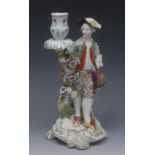 A Derby Patch Mark figural candlestick, a gallant, wearing a soft tricorn with a tied yellow bow,