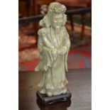 A Chinese soapstone figure, carved as a long-bearded official, he stands, holding a ruyi sceptre,