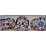 A pair of Japanese Imari shaped circular plates, decorated in the typical palette,