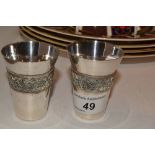 A pair of Russian white metal Vodka cups, tapering bodies, decorated with filligree band,