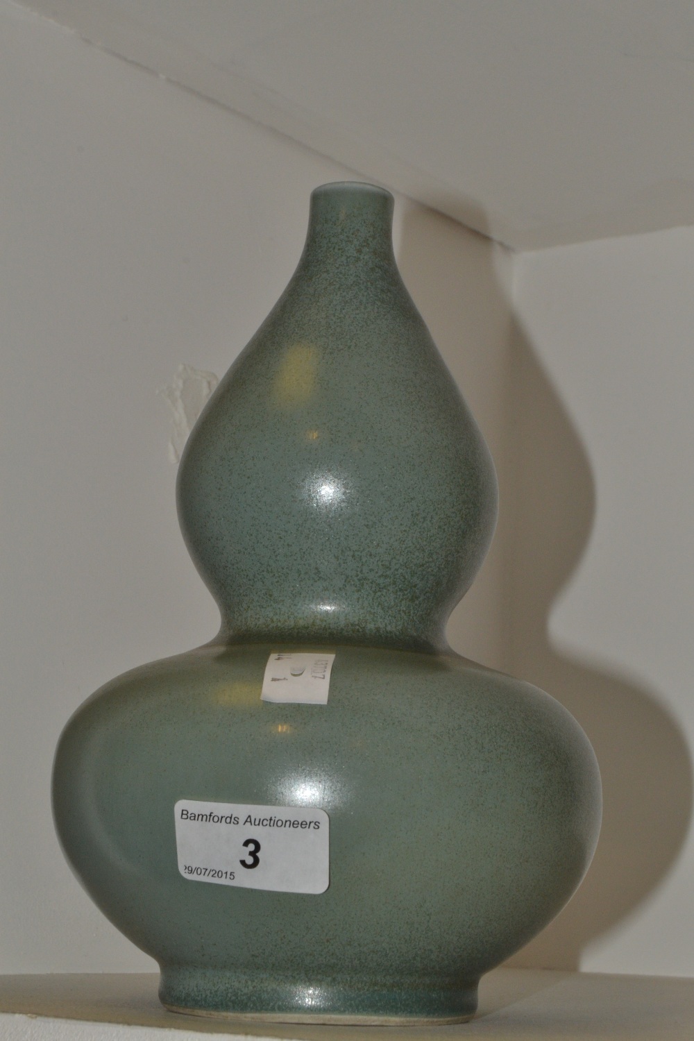 A Chinese monochrome double gourd vase, in a mottled green glaze, 23.