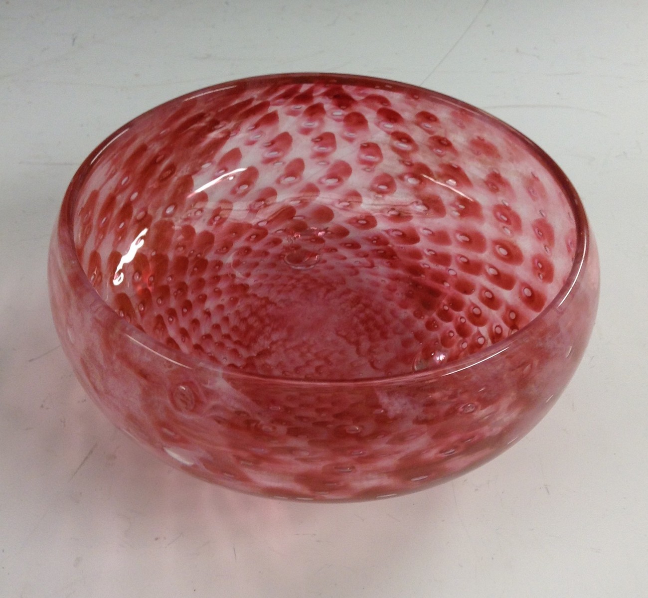 An Art Deco British pink glass bowl, with swirls of cream and bubble inclusions,