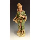 A Royal Dux figure of an Arab, standing carrying a water bottle, in burnished green and gilt,