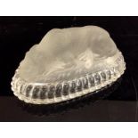A frosted pressed glass paperweight as a recumbent lion, beaded border, oval base,