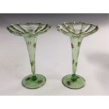 A pair of Stourbridge slender green glass bud vases, decorated with gilded roses,