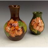 A Moorcroft Hibiscus baluster vase, tubelined pink hibiscus flowers on a brown ground,