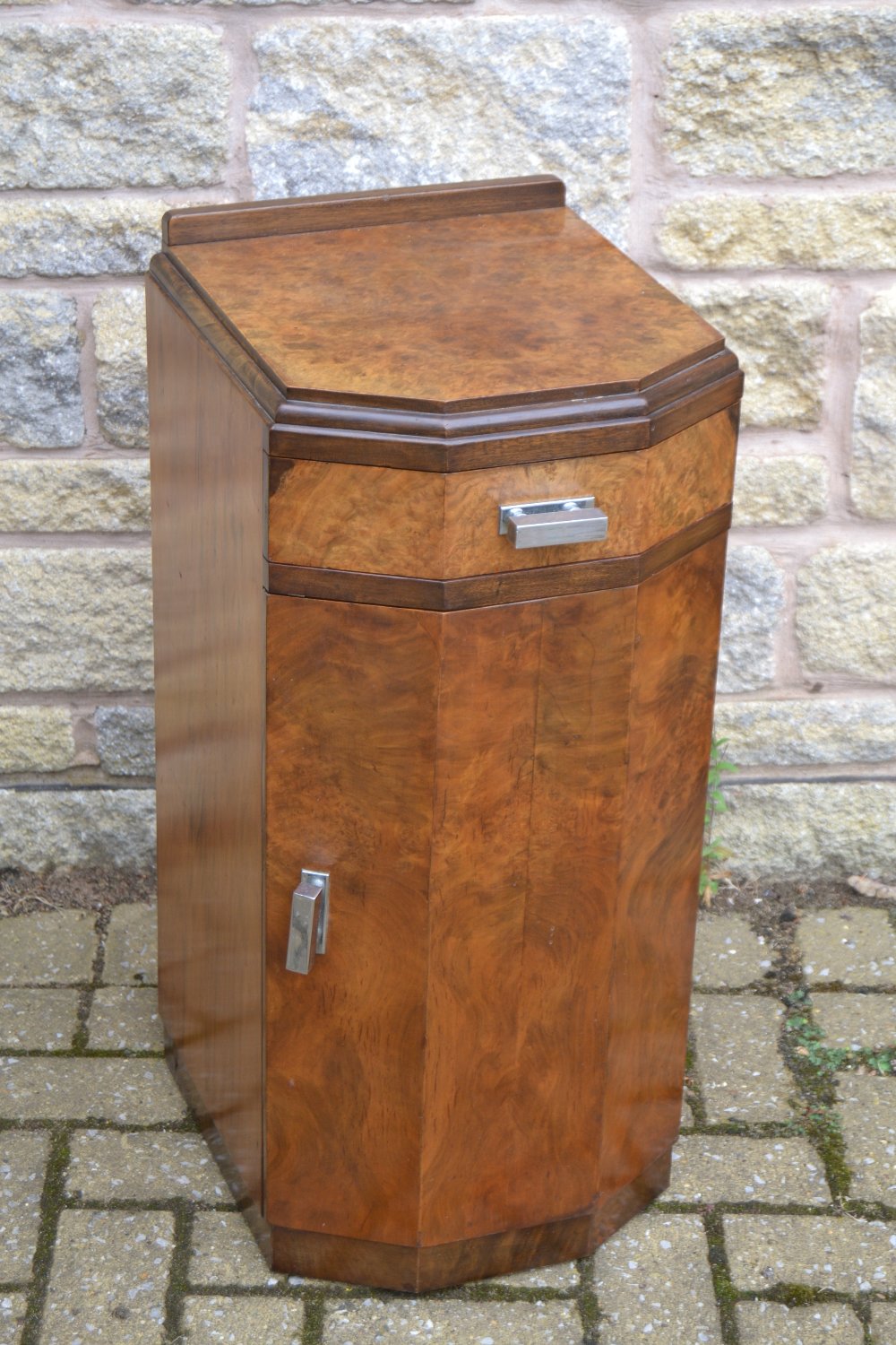 An Art Deco burr walnut bedside cabinet, of canted rectangular form,
