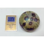 An Isle of Wight iridescent floral glass paperweight, cased in mica with purple flowers and foliage,