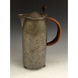 Archibald Knox for Liberty & Co - a Tudric pewter hot water jug, hammered overall,