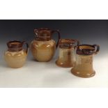 An interesting near pair of Doulton Lambeth salt glazed stoneware spreading cylindrical jugs,