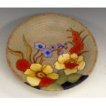 A Crown Devon M310 Mattita circular plate, tube lined flowers in hues of yellow, red and blue,