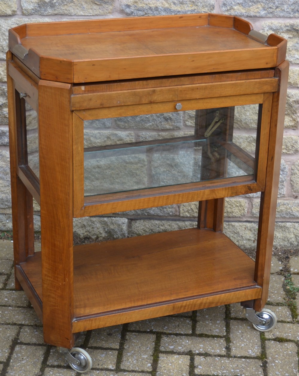 An Art Deco walnut canted rectangular two-tier tea trolley, the top with removable tray,