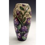 A modern Moorcroft vase, decorated with lavender and yellow flowers, on a cream and black ground,