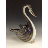 A 20th century Murano glass figure of a swan, moulded with blue, amber and clear glass stripes,