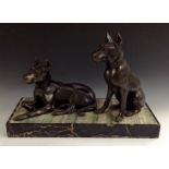 An Art Deco spelter and onyx group, of two doberman, one reclining, one seated,