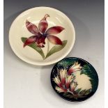 A Moorcroft circular dish,  tube line with a mauve orchid on a white ground, 18.