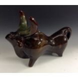 A Continental pottery model, as a stylized bull,  in tones of green and brown,