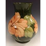 A Moorcroft Hibiscus pattern baluster vase, tube lined with large flowerheads and foliage, in