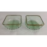 A pair of Art Nouveau square green glass bowls, in the style of Powell, gilded rims, c.