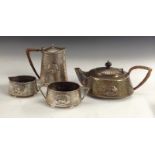 An English Pewter hammered four-piece tea set, embossed with sinuous flowerheads,