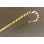 A novelty glass walking cane, amber glass cased in clear glass, spirally twisted handle and point,