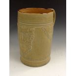 A large Royal Doulton salt glazed stoneware mug, moulded with a Bacchic mask, reeded scroll handle,
