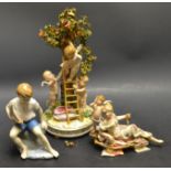 a German porcelain figural group of Putti picking fruit from a tree; another,