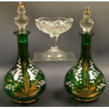 A pair of Victorian green and clear glass decanters,painted with gilt and white enameled flowers,