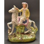 A Victorian Staffordshire flatback as a boy riding on the back of a zebra