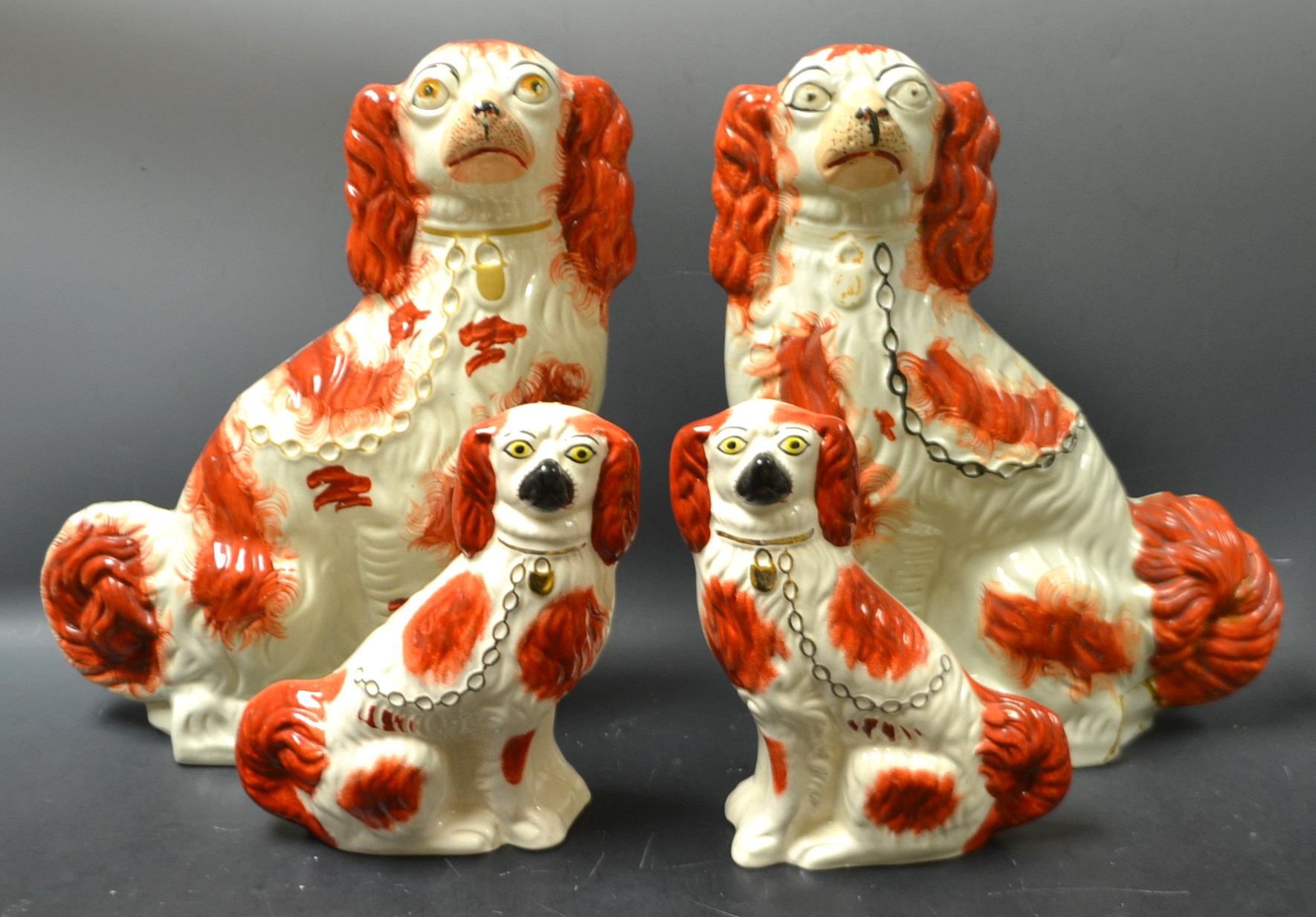 A pair of 19th century Staffordshire spaniels, Pyce coats, gilt collars; another,