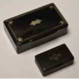 A paper mache snuff box decorated with stars on a black ground;