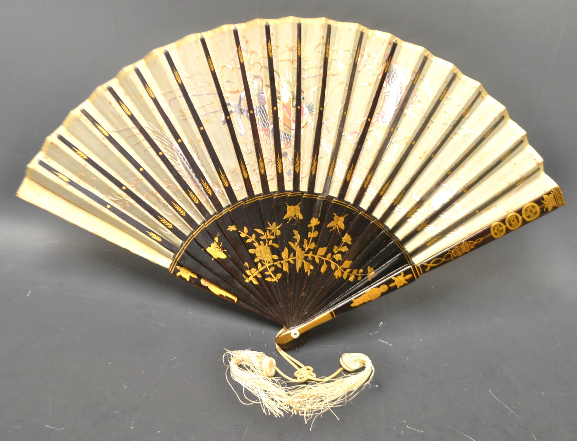 A Chinoiserie silk and lacquer twenty-two stick fan,
