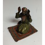 A Bergman-type cold painted bronze, of an Arab on a prayer rug, in colours,