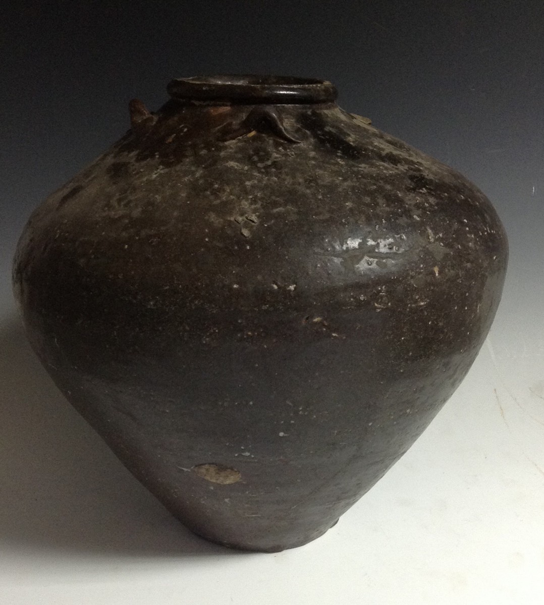 A Chinese earthenware storage jar, brown monochrome glaze, lug handles to shoulder,