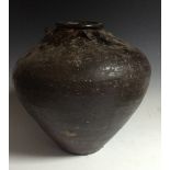 A Chinese earthenware storage jar, brown monochrome glaze, lug handles to shoulder,