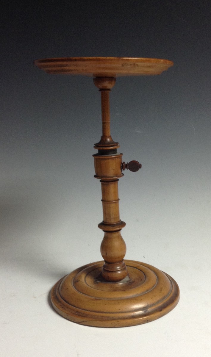 A George III sycamore table top adjustable candle stand, dished circular top turned column,