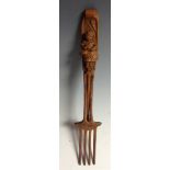 A Black Forest fork, the handle carved with a young girl stirring a pan, 26cm long, c.