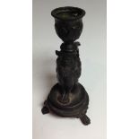 A 19th century dark patinated bronze novelty taperstick, cast as a bearded goblin,
