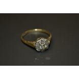 A diamond flower head cluster ring, central round brilliant cut diamond, approx 0.