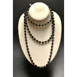 A faceted jet bead and white metal necklace,