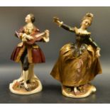 A pair of neopolitan classical figures of a gentleman playing the guitar and lady dancing to music,