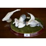 Three Lladro birds on oval mahogany stand